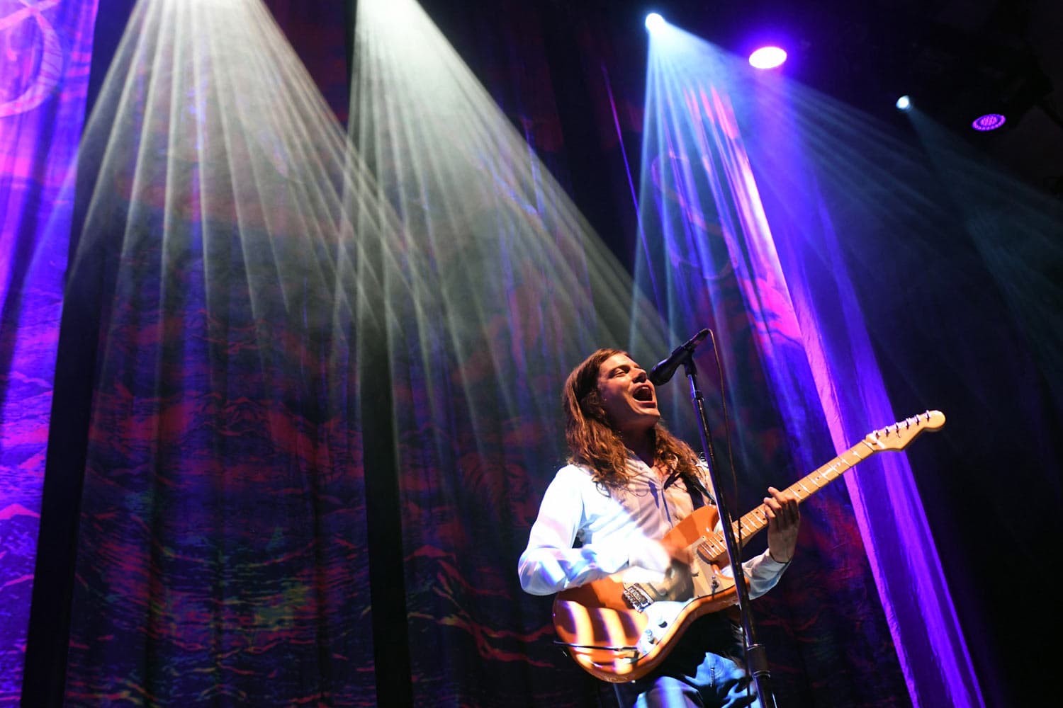 Concert photography of indie pop artist Garrett Borns (BORNS) performing at Sprint Pavilion. Alternative music venue performance with professional stage lighting and dynamic artist movement capture.