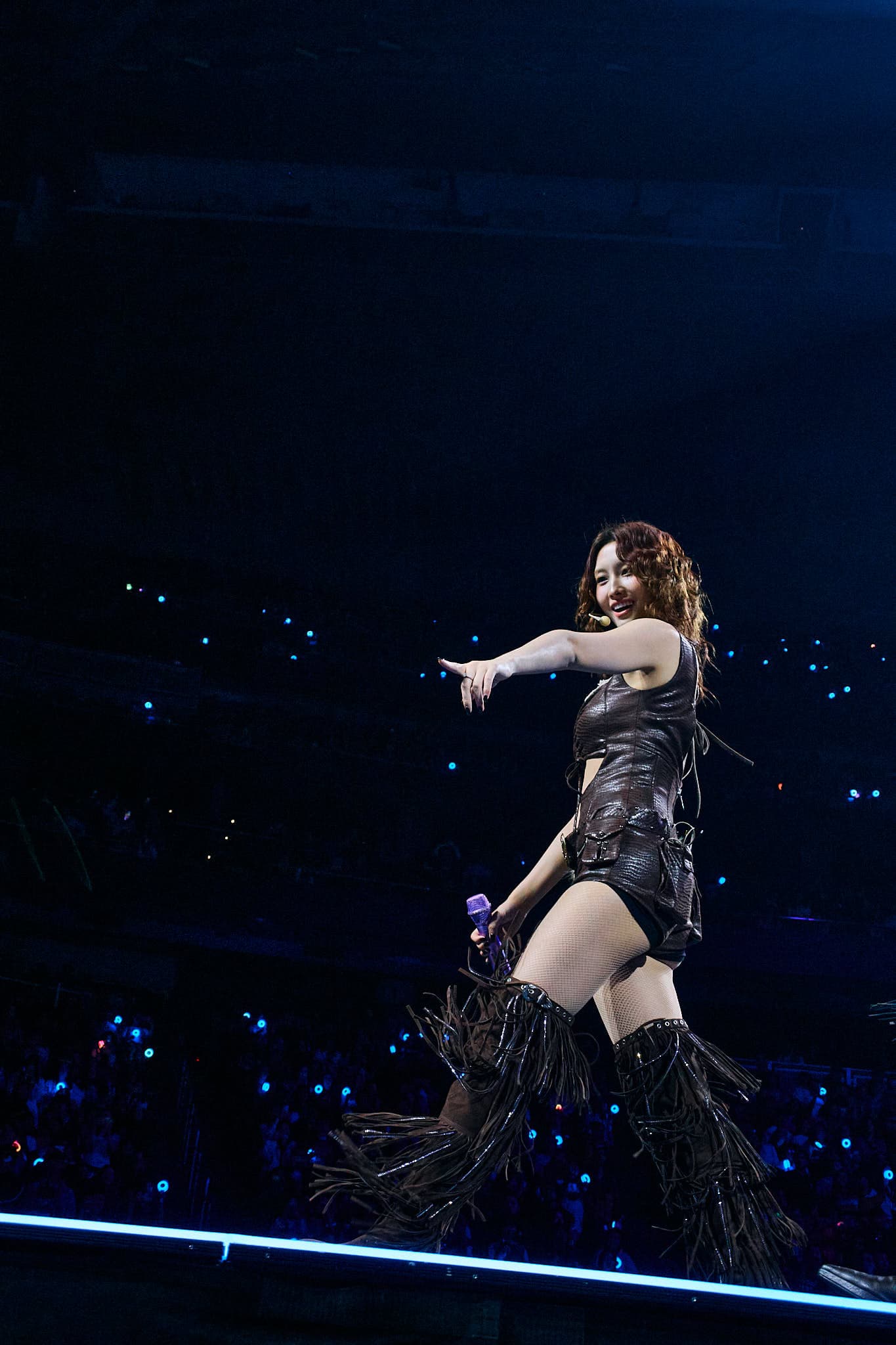 K-pop concert photography of TWICE member Momo performing during the This Is For World Tour. Dynamic idol performance capturing intricate choreography, stage presence, and professional concert lighting expertise.