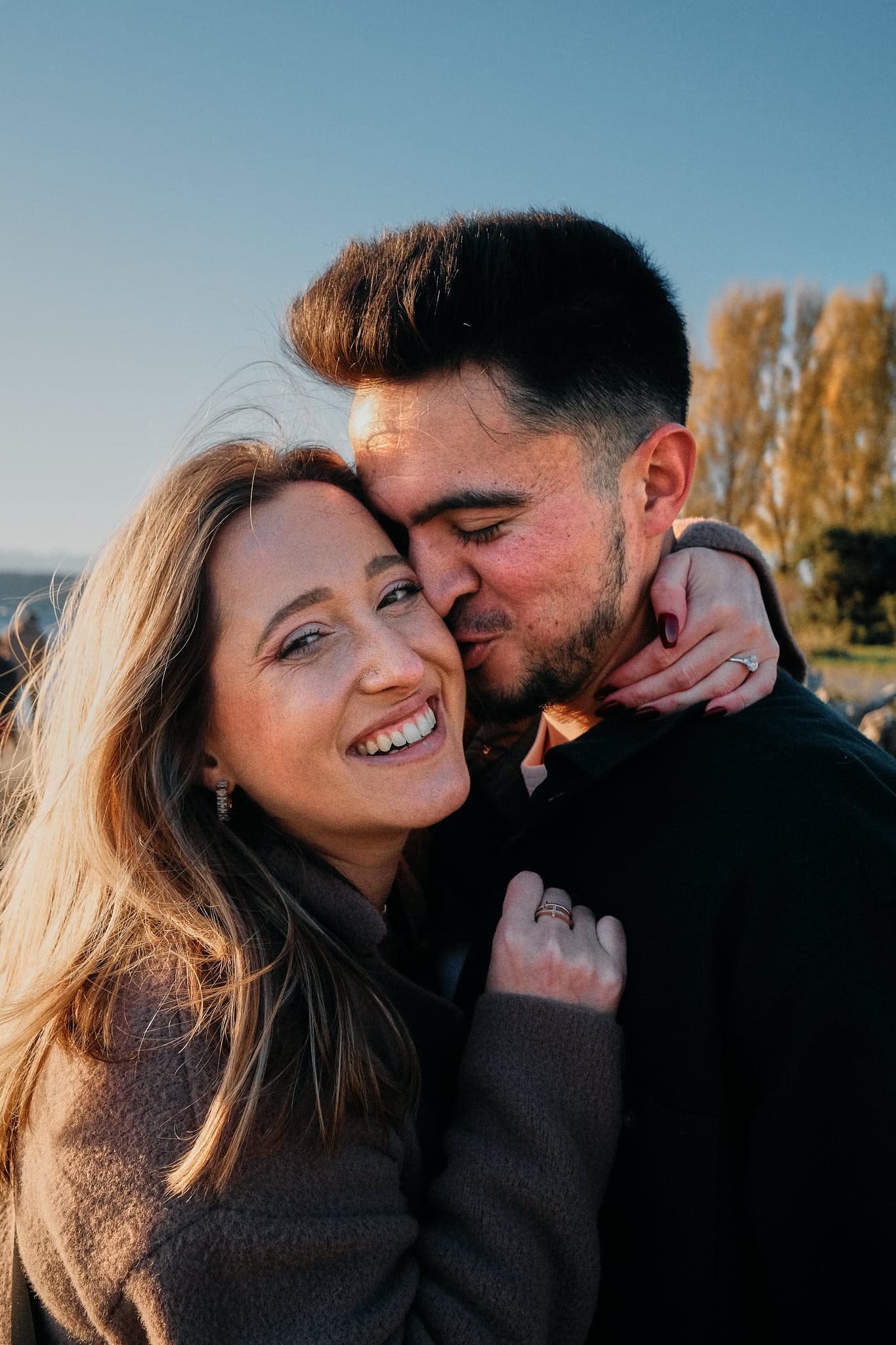 Engaged couple sharing a joyful embrace during golden-hour portrait session, capturing love and anticipation for their future together.