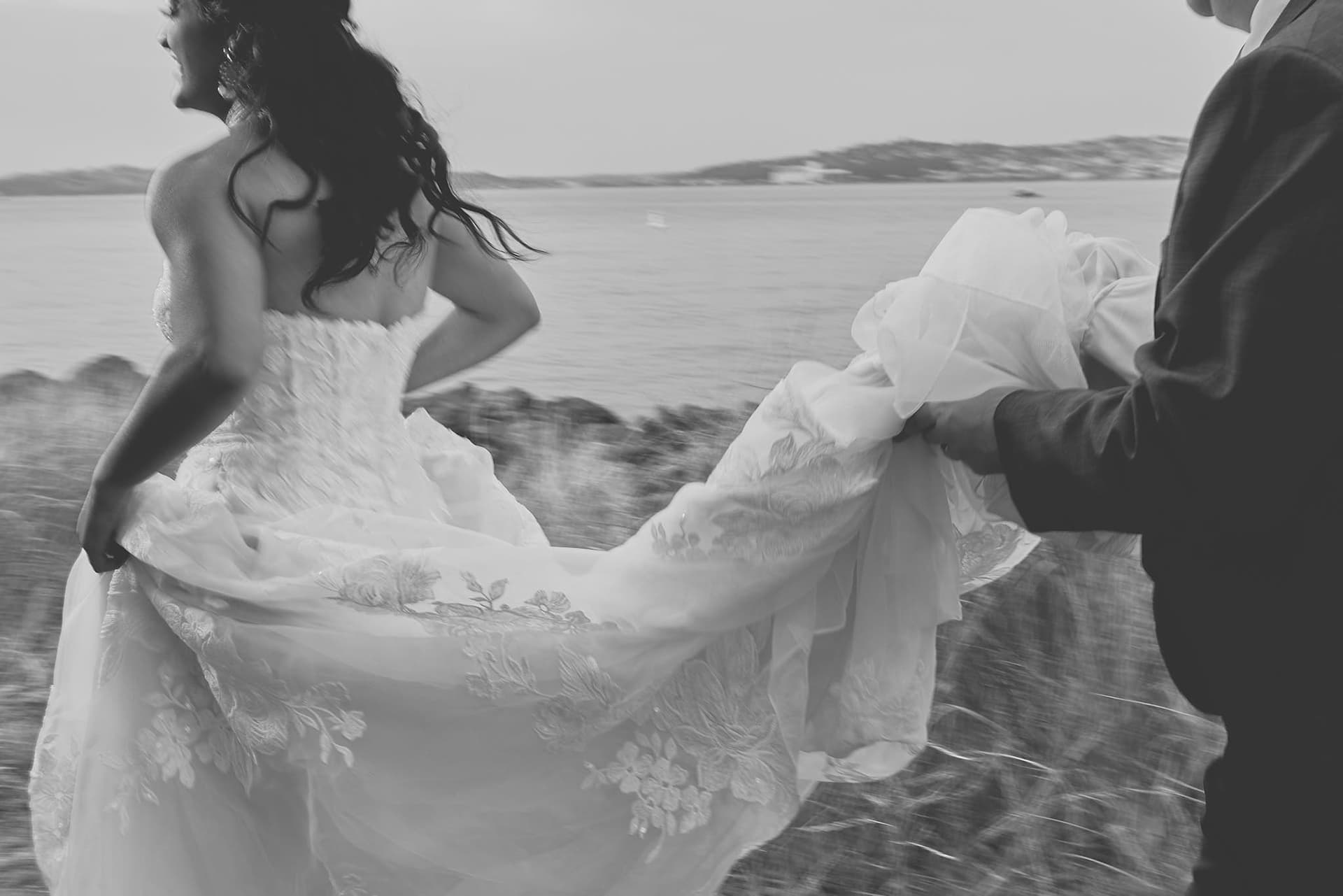 Authentic editorial wedding photo for publication featuring bride and groom in motion. Detail-oriented visual storytelling capturing genuine personality and presence through strategic lighting and composition.