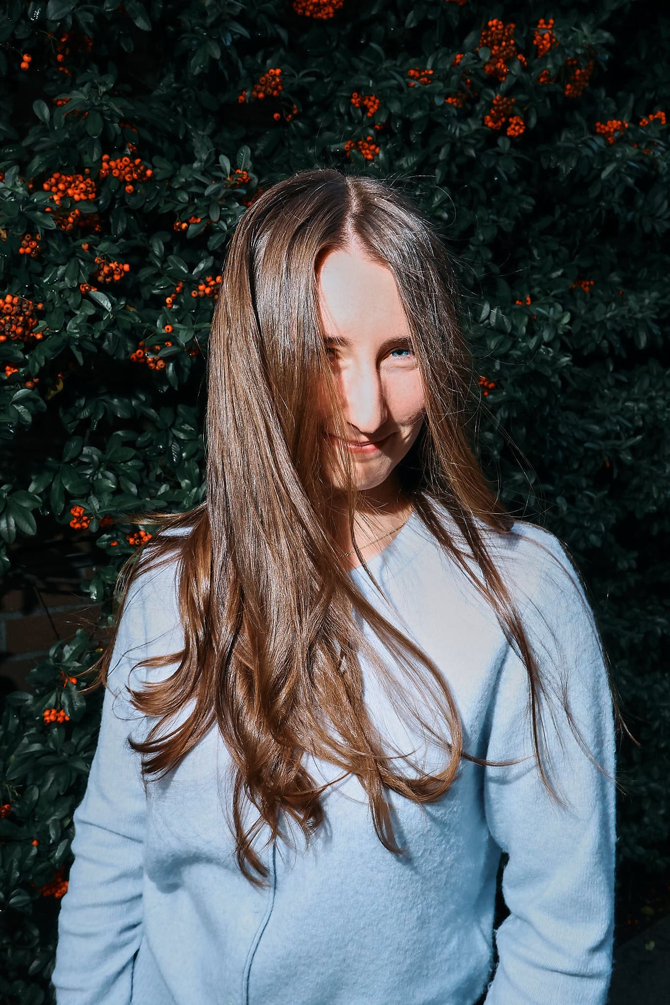 Young woman with a stylish haircut, captured in a modern portrait session. The clean background and soft lighting highlight her features, creating a fresh and contemporary look.