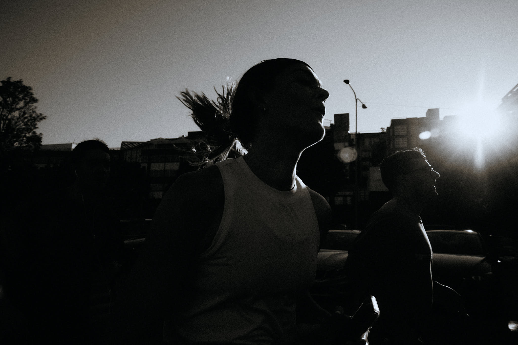 Black-and-white running photo of athletes in motion on a city street.