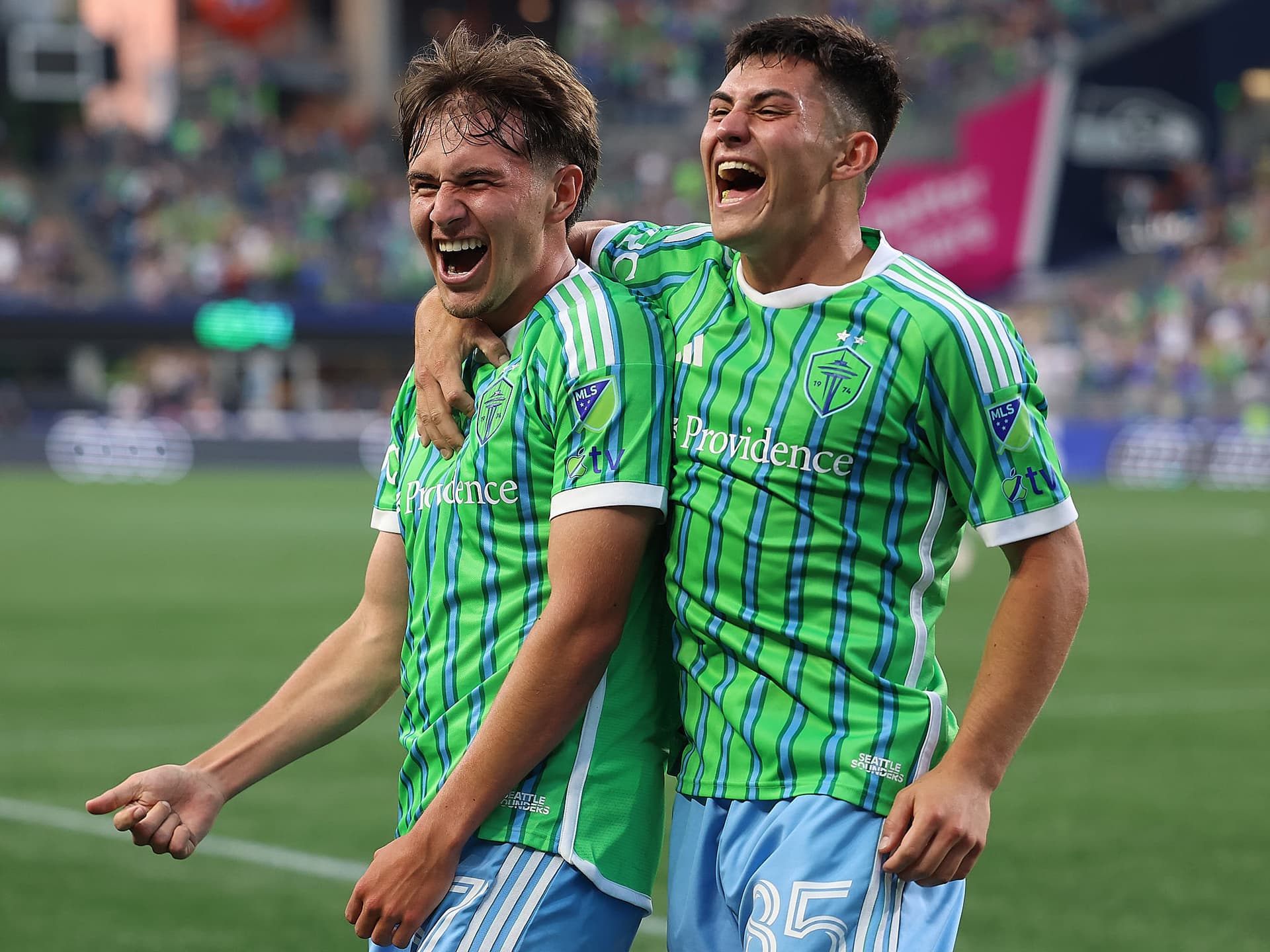 Snyder Brunell and Kalani Kossa Rienzi of Seattle Sounders FC celebrate after scoring a goal against Sporting Kansas City during the second half of an MLS match at Lumen Field.